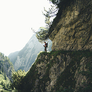 Hiker on a mountain path with an Alpine panorama